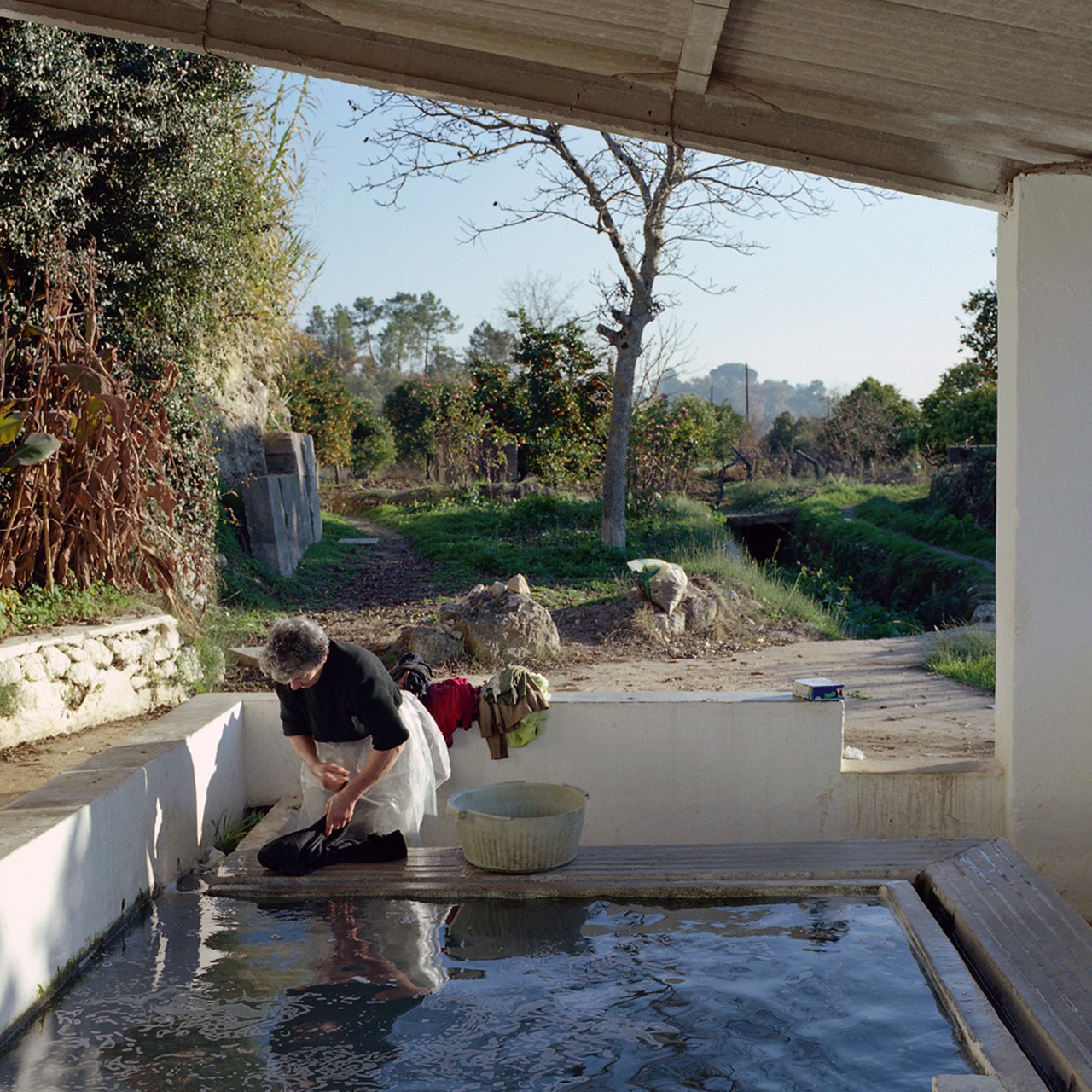 Ein portugiesisches Dorf, Frau am Brunnen, waschend